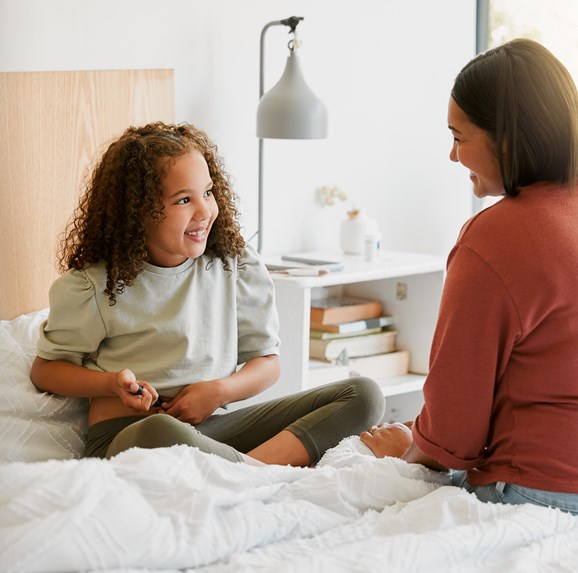 Una madre cariñosa enseña a su hijo a inyectarse insulina sola, luciendo feliz, orgullosa y valiente en casa. Una niña se inyecta un medidor de glucosa para detectar enfermedades crónicas.