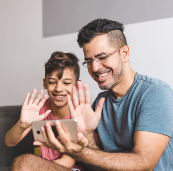 Papá e hijo comunicándose por videoconferencia.