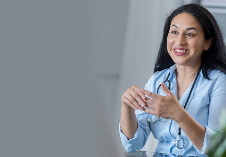 Una doctora adulta se sienta frente a su irreconocible paciente.