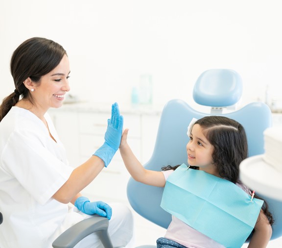 Niña choca los cinco con su dentista